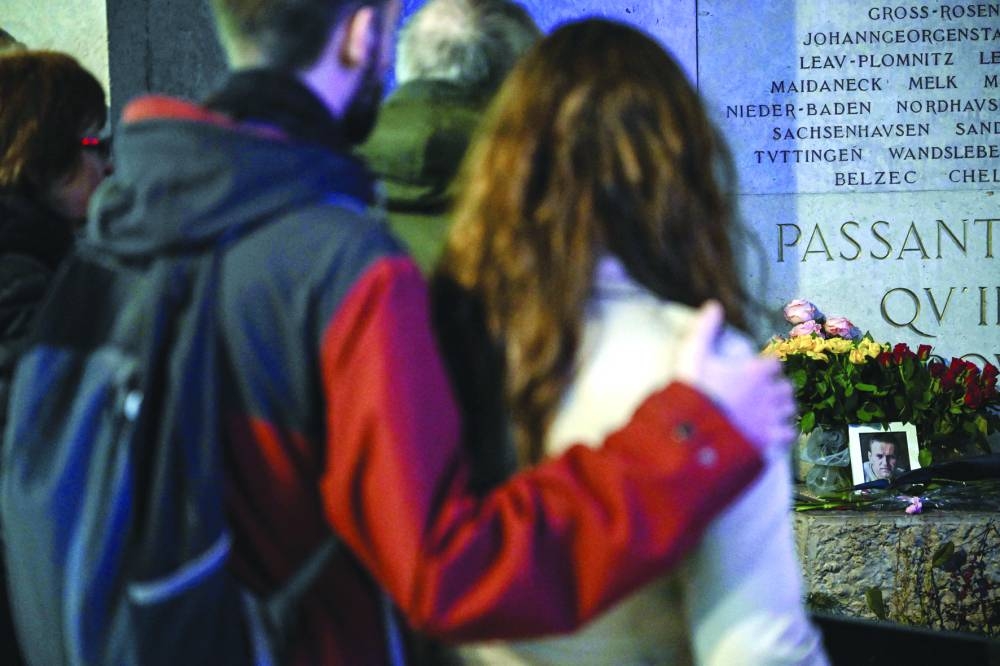 
Members of the public gather in front of a memorial of the French Interior Resistance in Lyon to pay tribute to late Russian opposition leader Alexei Navalny. 
