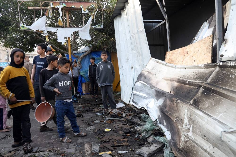 Children check the damage of a makeshift shelter in a camp set up by displaced Palestinians near the Emirati hospital in Rafah in the southern Gaza Strip, in which several people were reported killed when it was hit by Israeli bombing on Saturday. AFP