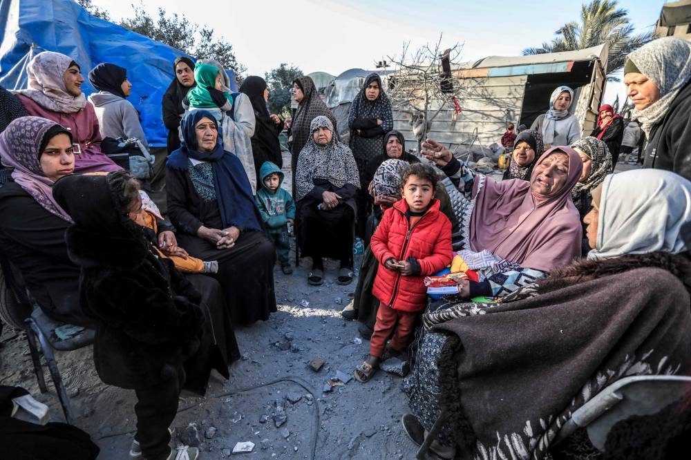 Palestinians sit amid tents and makeshift shelters that were destroyed in Israeli strikes in Deir El-Balah in central Gaza on Saturday. AFP