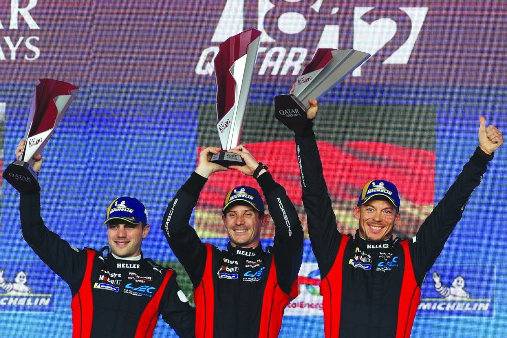 Porsche Penske Motorsport’s Laurens Vanthoor, Kevin Estre and Andre Lotterer celebrate after winning the Hypercar race at the Qatar 1812 KM – the season-opener of FIA World Endurance Championship at the Lusail International Circuit on Saturday. (AFP)