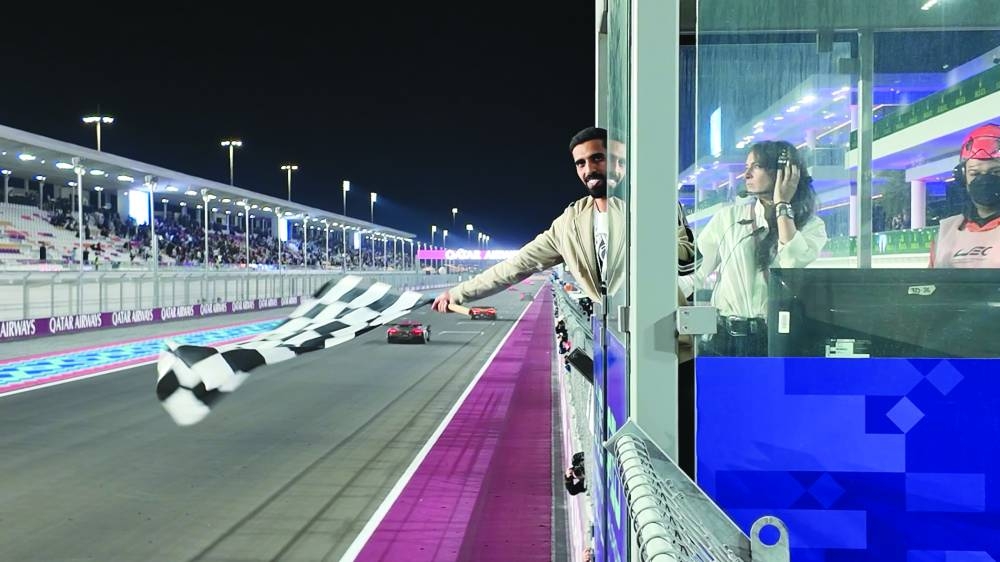
Qatar football team captain Hassan al-Haydos waves the checkered flag. 