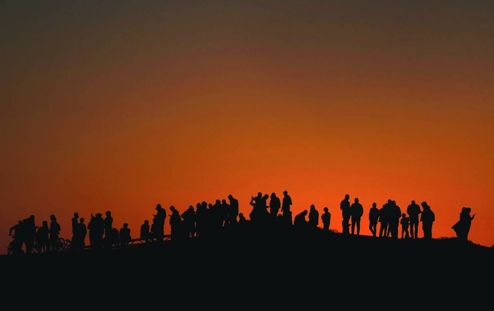 Displaced Palestinians try to get internet service on their phones through the Egyptian networks to communicate with their relatives, in Rafah Monday.