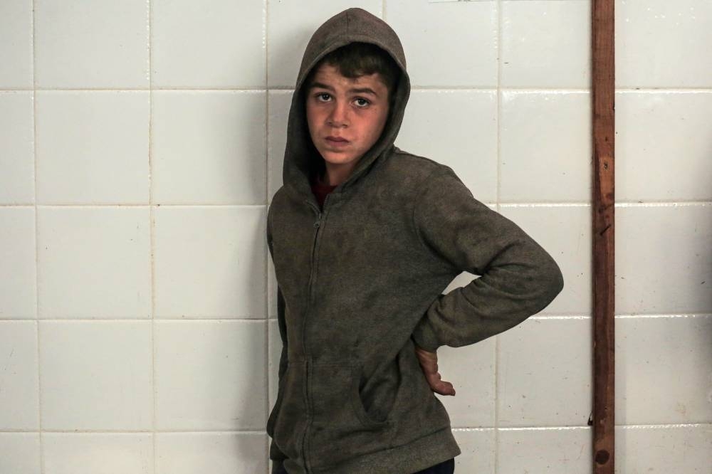 A Palestinian youth stands at the morgue of al-Aqsa hospital in Deir el-Balah as people mourn over the bodies of loved ones killed during Israeli bombardment, in the central Gaza Strip on Wednesday. AFP