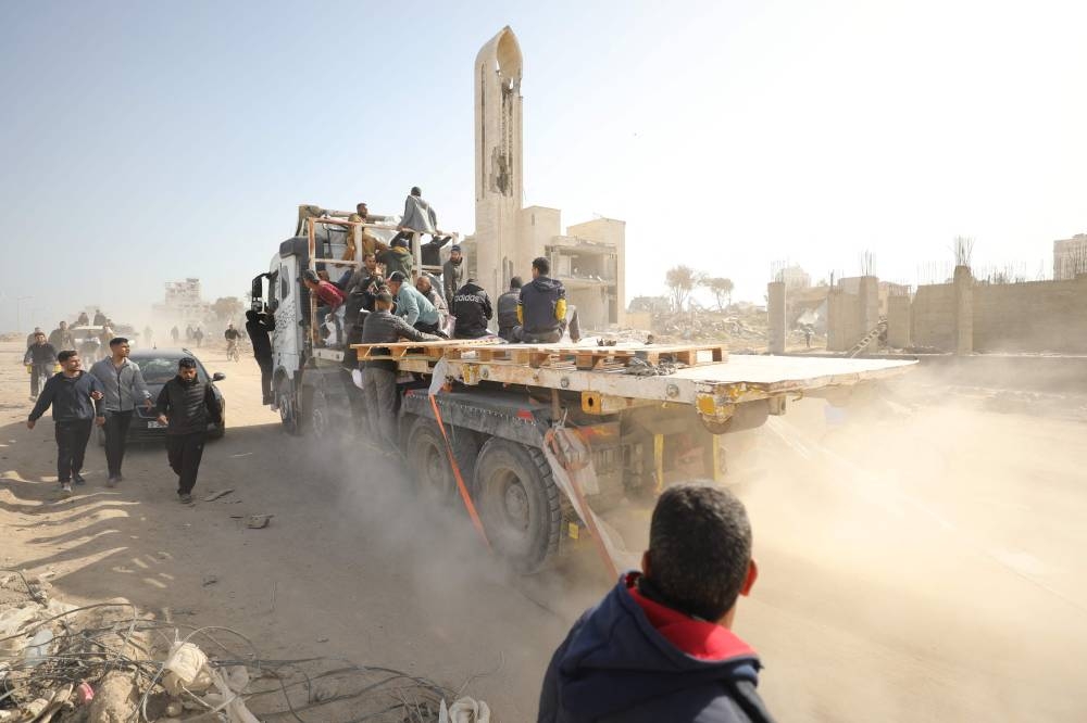 Palestinians transport bags of flour on the back of trucks as humanitarian aid arrives in Gaza City on Wednesday. AFP