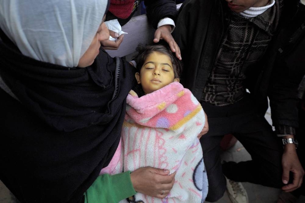 Relatives of a Palestinian girl killed during Israeli bombardment mourn over her body at al-Aqsa hospital in Deir el-Balah in the central Gaza Strip on Wednesday. AFP