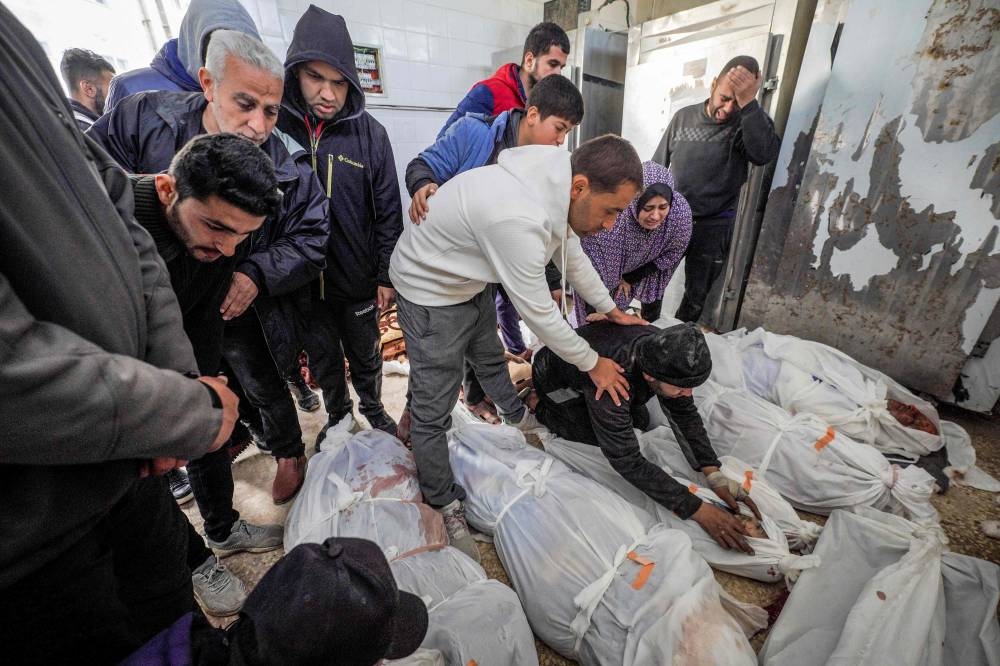 Palestinians react at al-Aqsa hospital in Deir el-Balah as they mourn over the bodies of loved ones killed during Israeli bombardment, in the central Gaza Strip on Wednesday. AFP