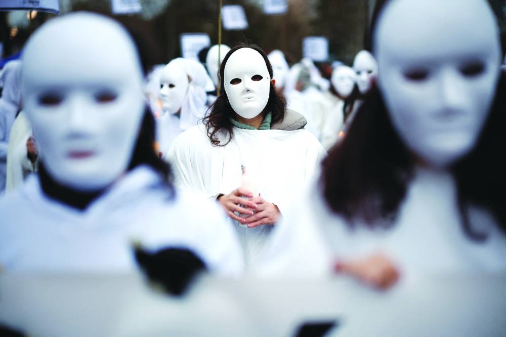 People holding light candles take part in a protest to mark International Women's Day in Madrid.
