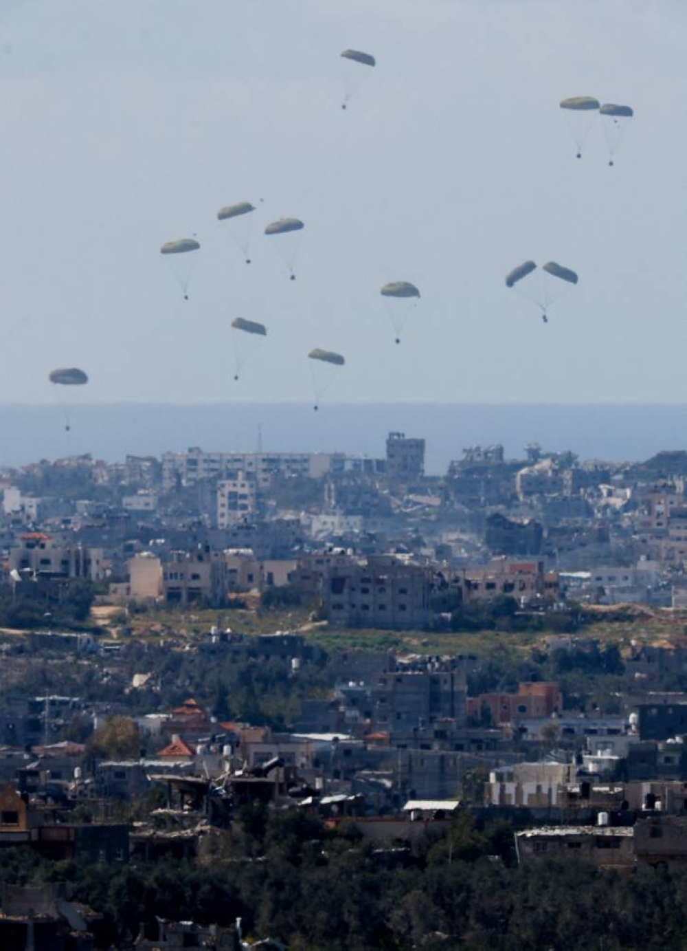 Packages fall towards northern Gaza, after being dropped from a military aircraft as seen from Israel's border with Gaza, in southern Israel on Saturday. REUTERS