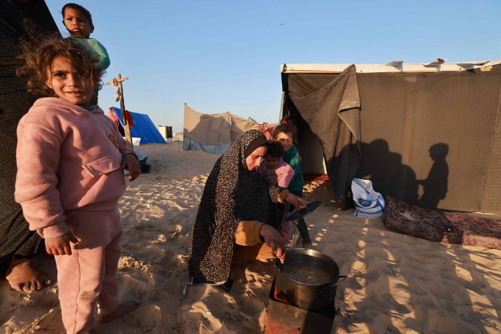 Displaced Palestinians prepare an Iftar meal on the first day of the Muslim holy fasting month of Ramadan, outside a tent in Rafah in the southern Gaza Strip on Monday. AFP
