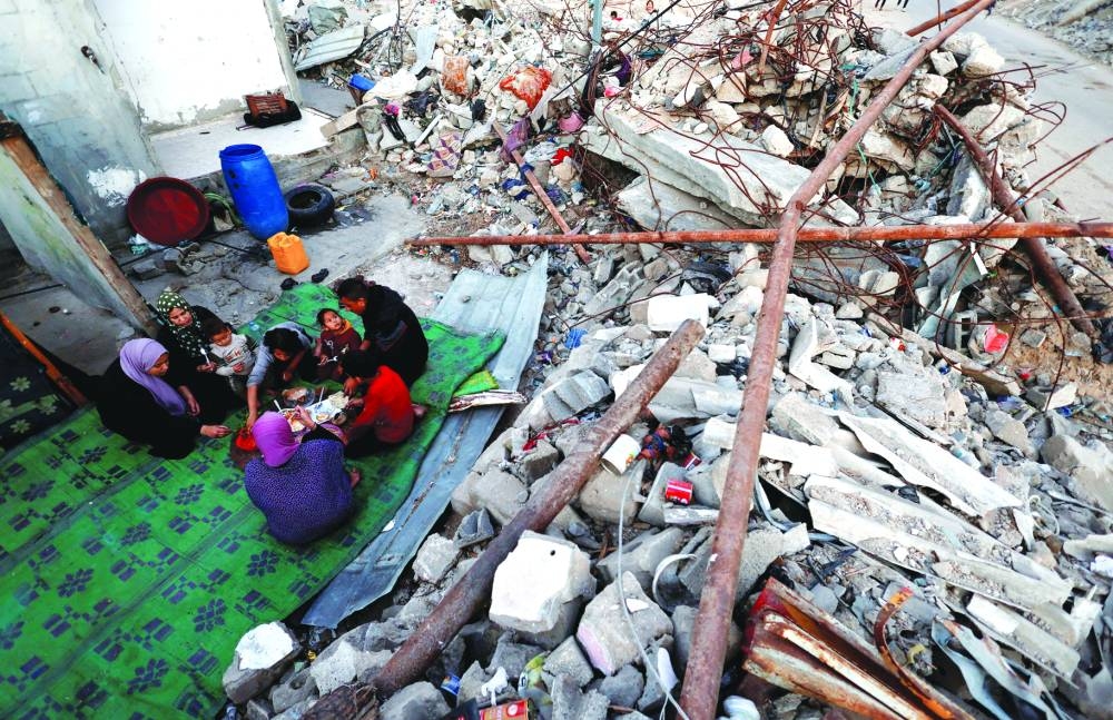 Palestinians break their fast amid the rubble of their destroyed home during the Muslim holy fasting month of Ramadan, in Rafah, Wednesday.
