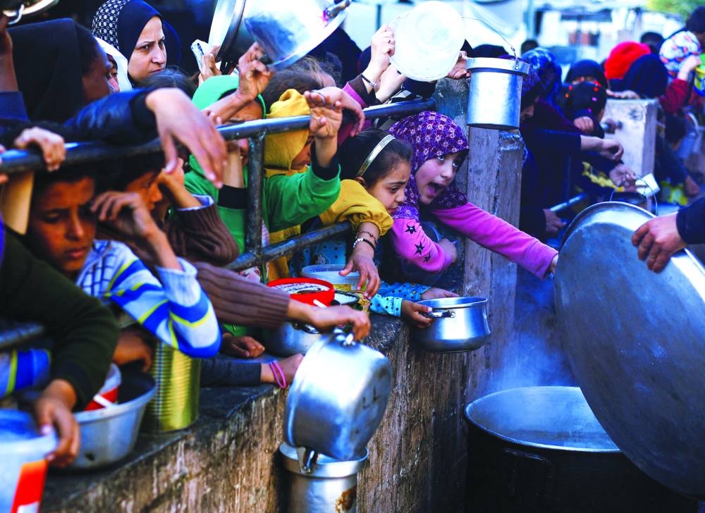 Palestinian children wait to receive food during the Muslim holy fasting month of Ramadan, in Rafah, Wednesday.