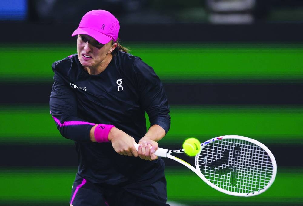 Iga Swiatek of Poland plays a backhan against Yulia Putintseva of Kazakhstan in their fourth round match during the BNP Paribas Open at Indian Wells Tennis Garden in Indian Wells, California. (AFP)