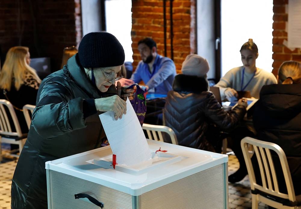A woman casts her ballot at a polling station during the presidential election in Moscow, Russia March 15, 2024. REUTERS/Evgenia Novozhenina