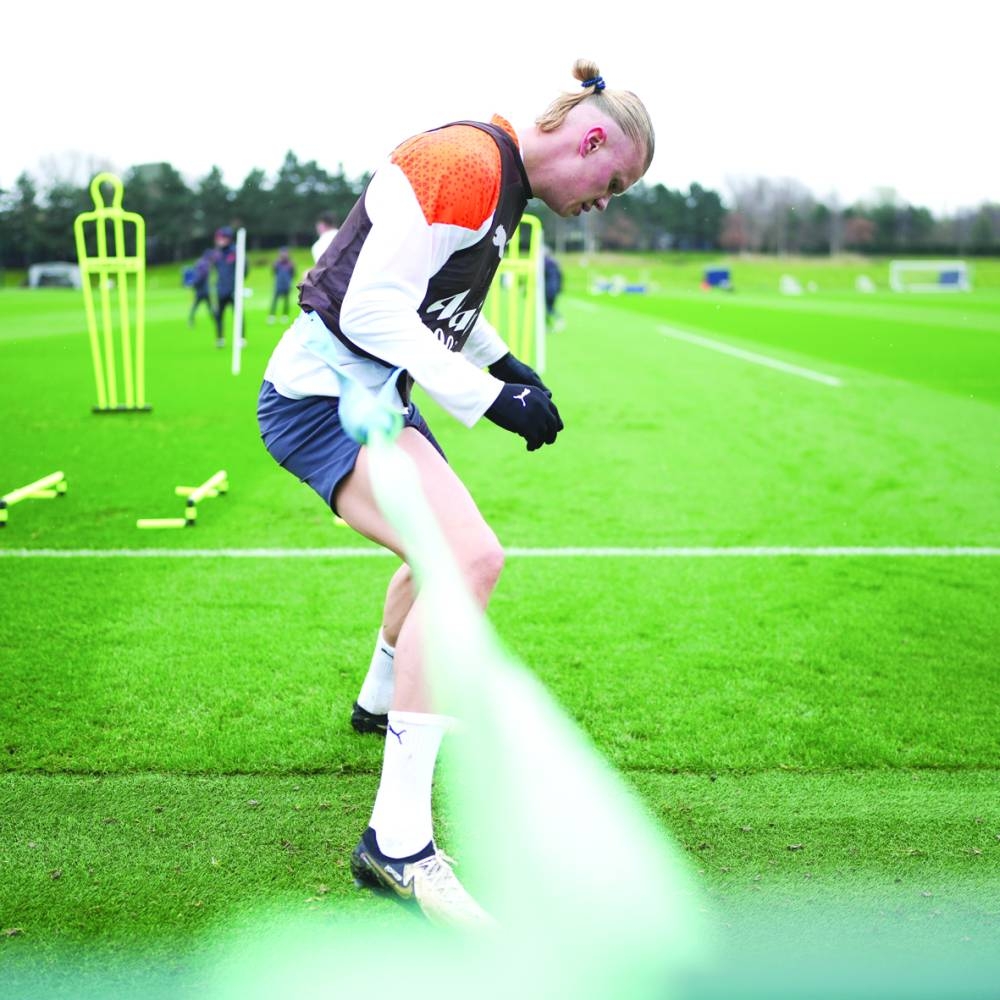 
Manchester City’s Erling Haaland breaks a sweat during a team training session. Inset: Man City coach Pep Guardiola watches his players during training. (@ManCity) 