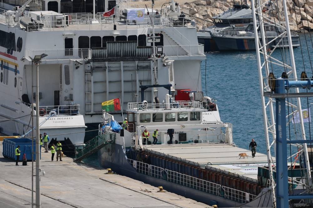 A police officer uses a sniffer dog to inspect the cargo ship loaded with humanitarian aid for Gaza in the port of Larnaca, Cyprus March on Saturday. REUTERS
