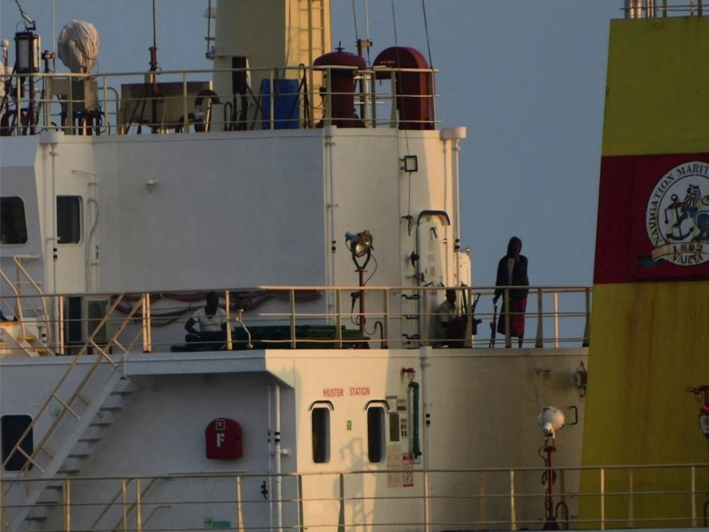People with weapons stand onboard the Maltese-flagged bulk cargo vessel Ruen seized by Somali pirates, which was intercepted by the Indian Navy, at sea. SpokespersonNavy via X/Handout via REUTERS