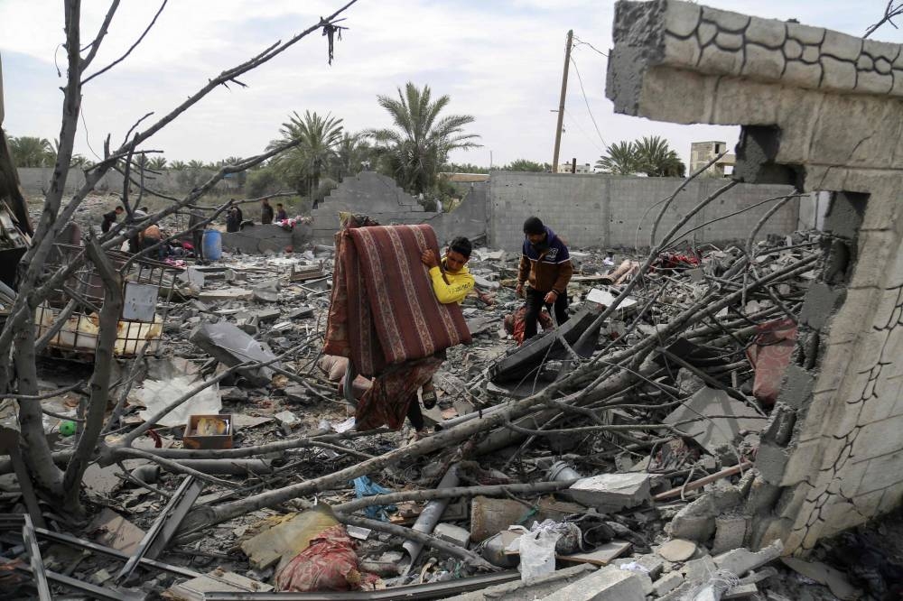 Palestinians search the rubble of the Tabatibi family home following overnight Israeli bombardment west of the Nuseirat refugee camp in the central Gaza Strip on Saturday. AFP