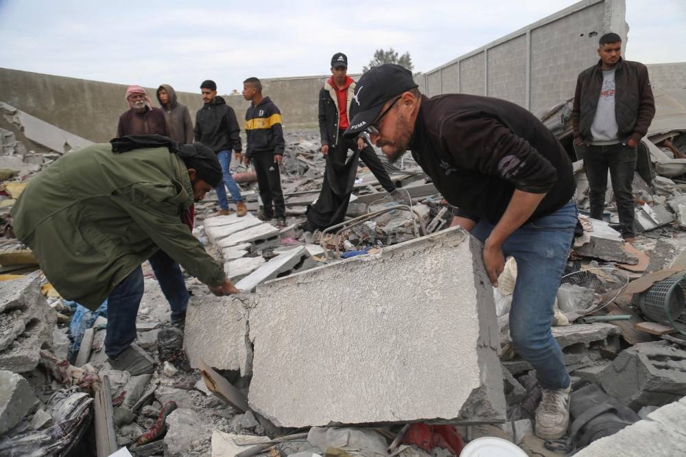 Palestinians search the rubble of the Tabatibi family home following overnight Israeli bombardment west of the Nuseirat refugee camp in the central Gaza Strip Saturday. AFP