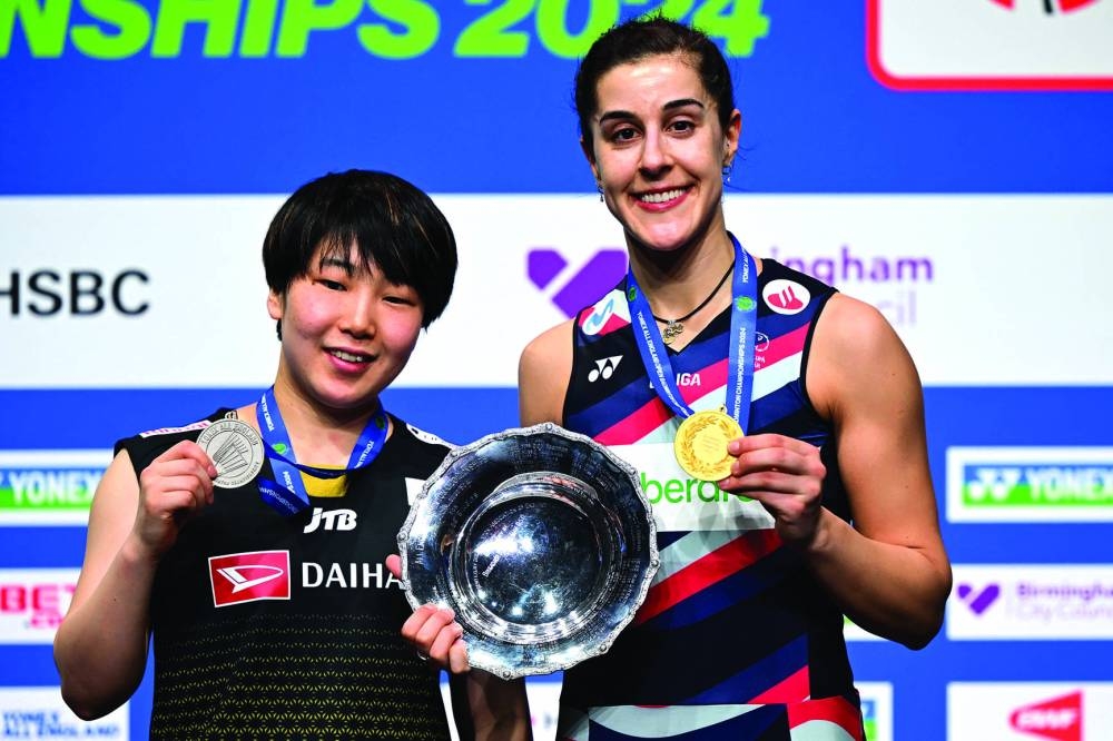 Japan's Akane Yamaguchi (left) and winner Spain's Carolina Marin are seen on the podium after competing in the women's singles final at the All England Open Badminton Championships at the Utilita Arena in Birmingham, central England, yesterday. (AFP)