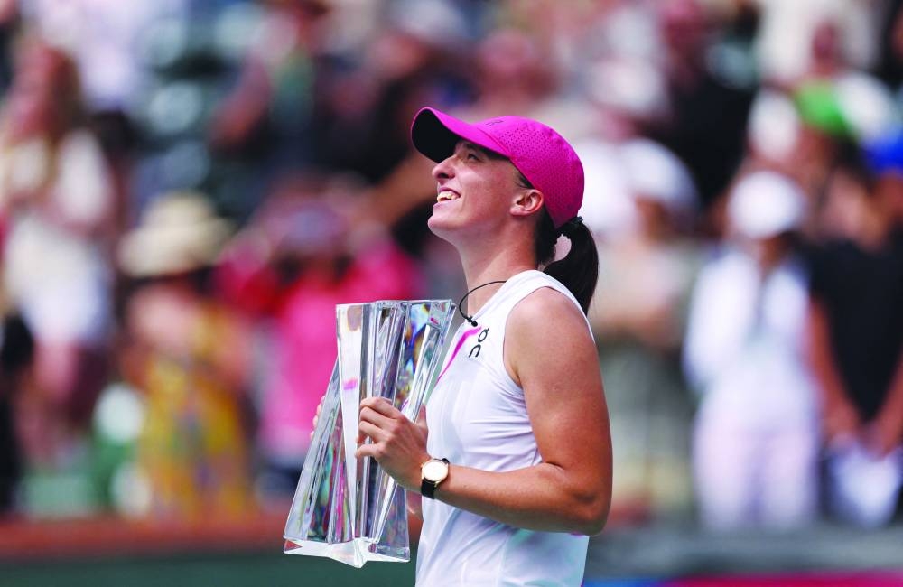 Iga Swiatek of Poland holds her winner's trophy after her straight-sets victory against Maria Sakkari of Greece in the final during the BNP Paribas Open at Indian Wells Tennis Garden in Indian Wells, California. (AFP)
