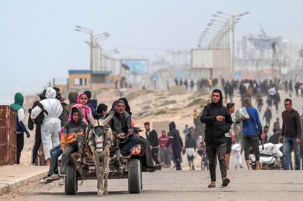 Displaced Palestinians fleeing from the area in the vicinity of Gaza City's al-Shifa hospital arrive via the coastal highway at the Nuseirat refugee camp in the central Gaza Strip on Monday. AFP