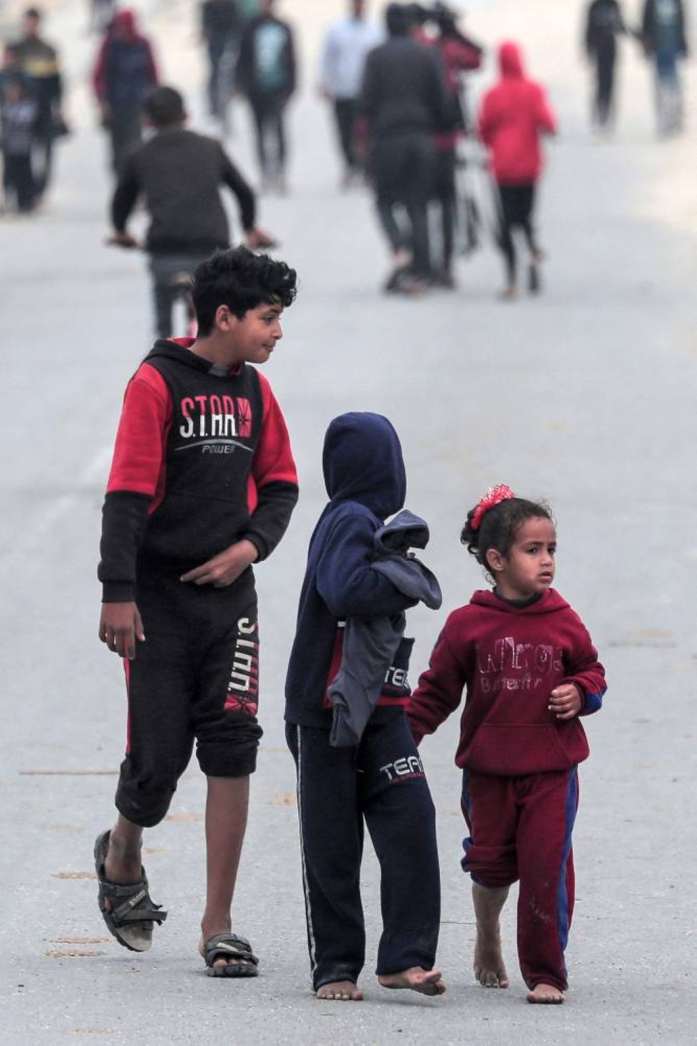 Children walk along the coastal highway with other displaced Palestinians fleeing from the area in the vicinity of Gaza City's al-Shifa hospital, upon arrival at the Nuseirat refugee camp in the central Gaza Strip on Monday. AFP