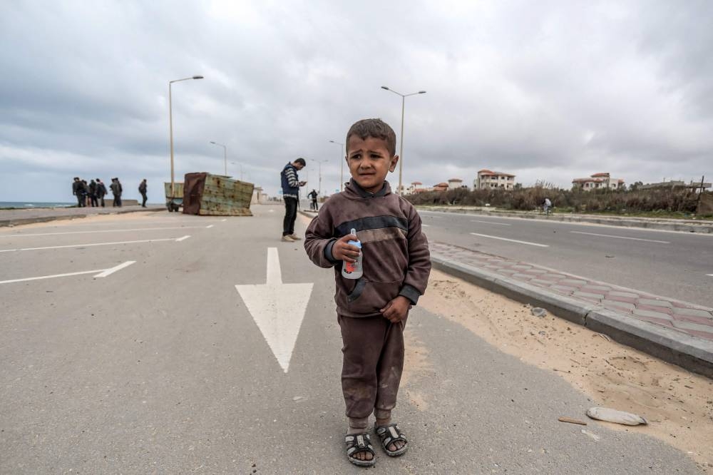 A child reacts as he walks along the coastal highway with other displaced Palestinians fleeing from the area in the vicinity of Gaza City's al-Shifa hospital, upon arrival at the Nuseirat refugee camp in the central Gaza Strip on Monday. AFP