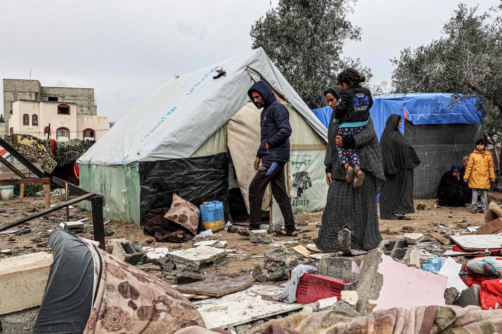 Displaced Palestinians inspect the damage to their tents following overnight Israeli bombardment at the Rafah refugee camp in the southern Gaza Strip Tuesday. AFP