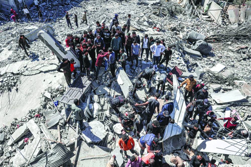 People inspect the rubble of a building that collapsed following an Israeli air strike in the Rafah refugee camp Wednesday. 