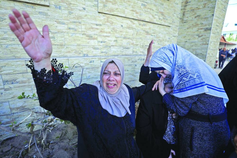 
Women react during the funeral of Palestinian men from an array of clans and factions, who secure aid convoys in Gaza, after they were killed in an Israeli strike, in Gaza City, yesterday. 