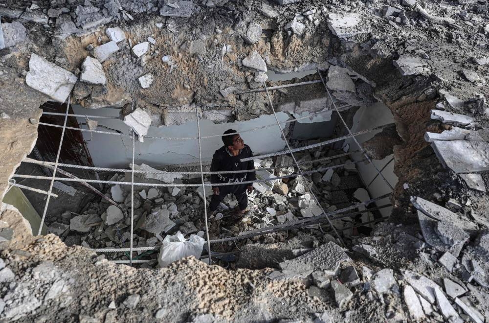 A young Palestinian checks the damage inside a home hit by Israeli bombardment in Rafah in the southern Gaza Strip on Friday. AFP