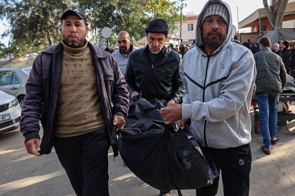 Palestinians carry a body of a relative killed in an Israeli bombardment, to the morgue of the European hospital in Khan Yunis in the southern Gaza Strip on Saturday. AFP