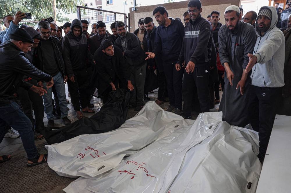 Palestinians surround the bodies of relatives killed in an Israeli bombardment, at the morgue of the European hospital in Khan Yunis in the southern Gaza Strip on Saturday. AFP