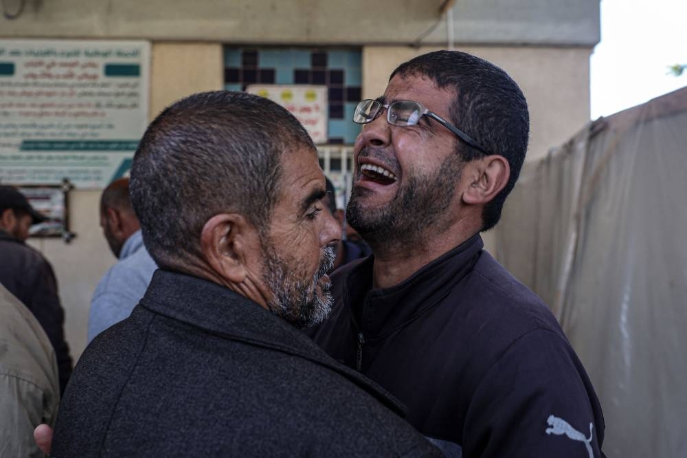 A Palestinian man mourns the death of relatives killed in an Israeli bombardment,  at the morgue of the European hospital in Khan Yunis in the southern Gaza Strip on Saturday. AFP