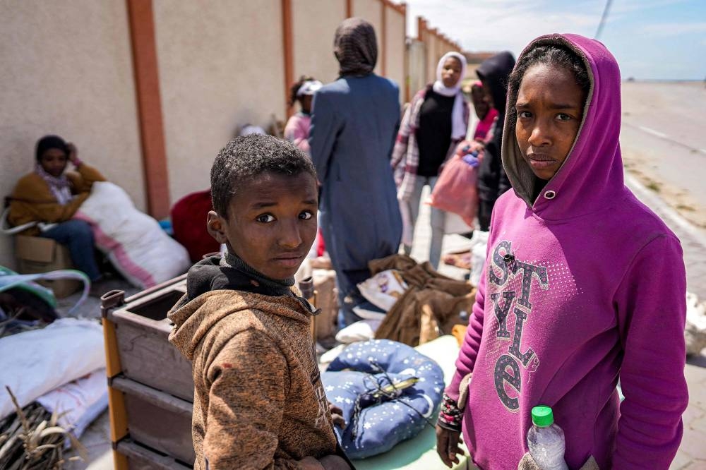 Children look on as they stand with other displaced people evacuating from Gaza City on Monday. AFP