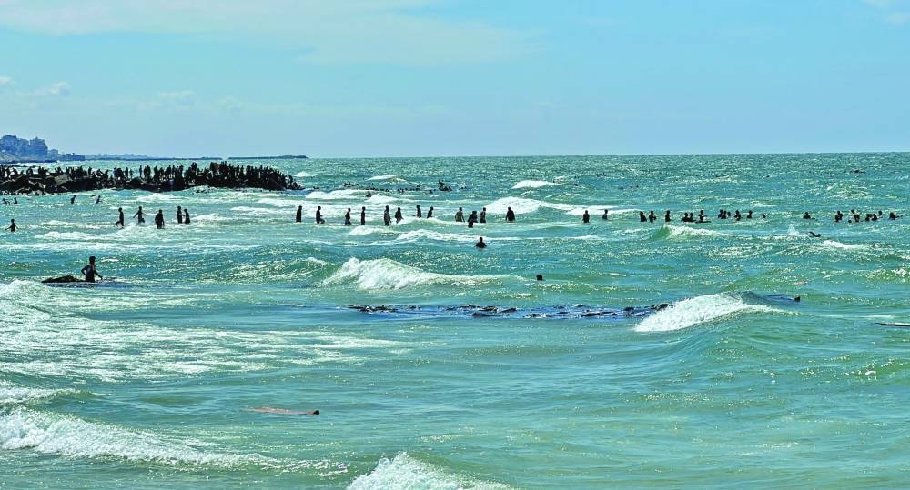 Palestinians gather at the sea to collect aid airdropped by an airplane,  in the northern Gaza Strip