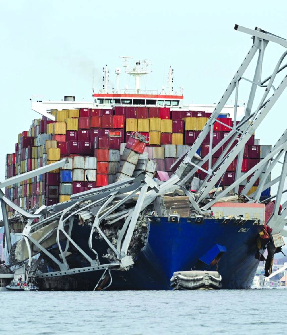 The steel frame of the Francis Scott Key Bridge sits on top of the container ship Dali after the bridge collapsed, Baltimore, Maryland, yesterday. (AFP)