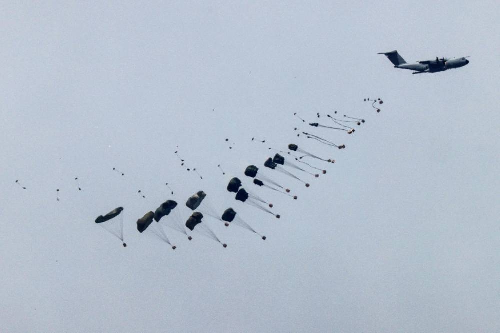 A military aircraft releasing parachutes of humanitarian aid over the besieged Palestinian territory on Wednesday. AFP
