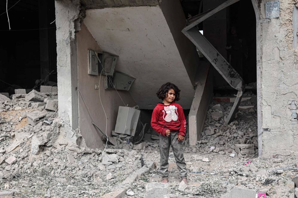 A Palestinian child near a building damaged in the overnight Israeli bombardment in Rafah in the southern Gaza Strip, on Friday. AFP