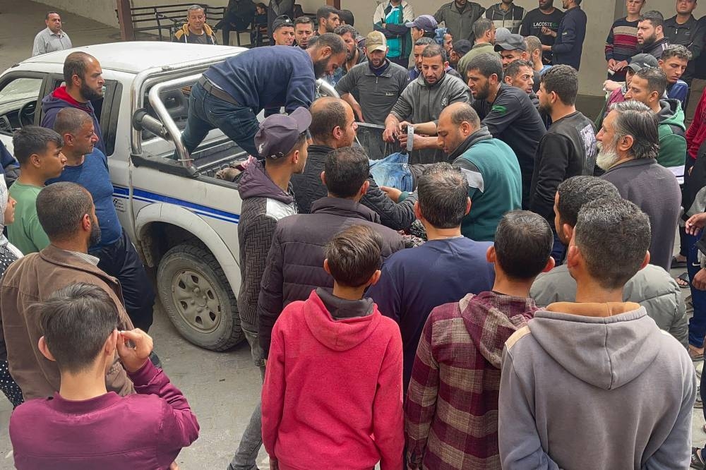 People gather around a truck carrying bodies of Palestinian policemen, after they were reportedly targeted by Israeli bombardment, in Gaza City, on Friday. AFP