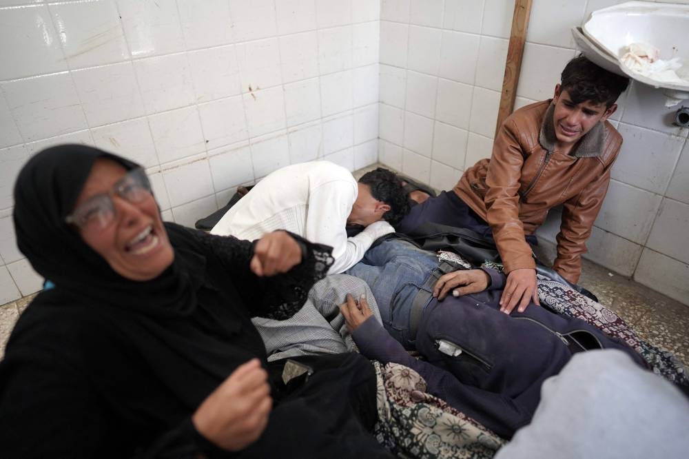 Relatives mourn over the dead body of a Palestinian man, reportedly killed in Israeli attacks, at the Al-Aqsa Martyrs Hospital in Deir al-Balah, central Gaza Strip, on Friday. AFP