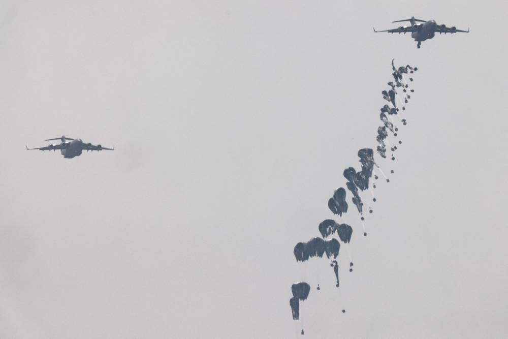 Humanitarian aid falls through the sky towards the Gaza Strip after being dropped from an aircraft as seen from Israel on Friday. REUTERS