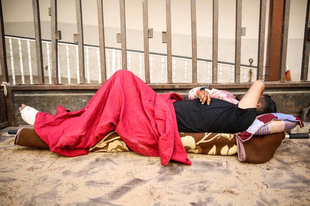 A wounded Palestinian man lies on a stretcher at the floor of the Baptist Hospital in Gaza City, on Sunday. AFP