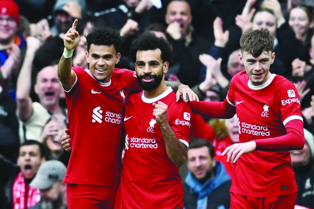 
Liverpool striker Mohamed Salah (centre) celebrates with teammates after scoring his team second goal during the Premier League match against Brighton and Hove Albion at Anfield in Liverpool yesterday. (AFP) 