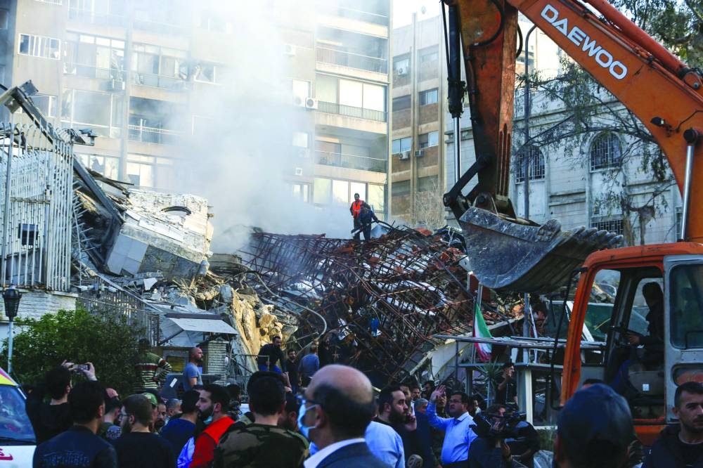 Emergency and security personnel inspect the rubble at the site of strikes which hit a building annexed to the Iranian embassy in Syria's capital Damascus, Smoke rises after the Israeli strike on a building close to the Iranian embassy in Damascus, Monday.