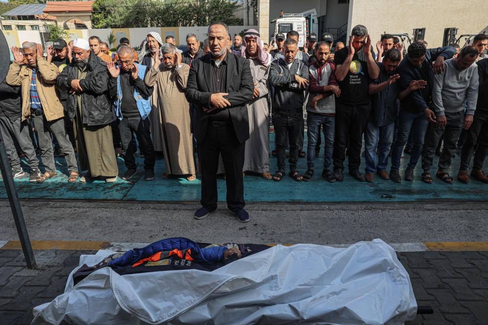 Relatives and friends pray by the body of Saif Abu Taha, a staff member of the US-based aid group World Central Kitchen who was killed as Israeli strikes hit a convoy of the NGO delivering food aid in Gaza. AFP