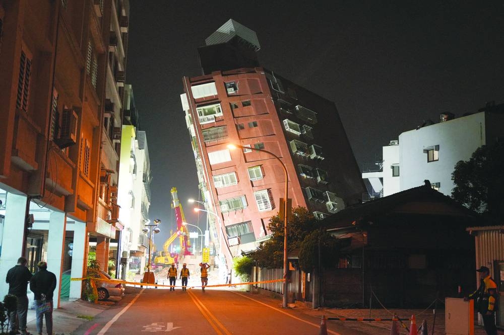 Workers near the site where a building collapsed following an earthquake, in Hualien, Taiwan Wednesday