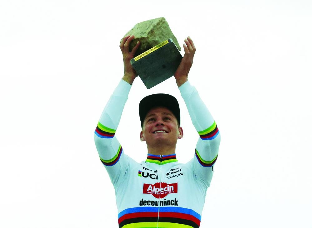 
Alpecin-Deceuninck’s Mathieu van der Poel Mathieu Van Der Poel celebrates his victory with teammate Belgian rider Jasper Philipsen (second right) after winning the 121st edition of the Paris-Roubaix yesterday. Right: Mathieu van der Poel celebrates with the trophy on the podium after winning the Paris-Roubaix. (Reuters/AFP) 