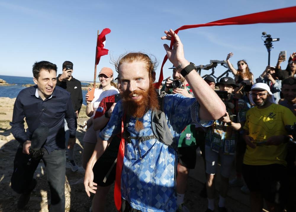 Britain's Russ Cook reacts after becoming the first person to run the entire length of Africa. REUTERS