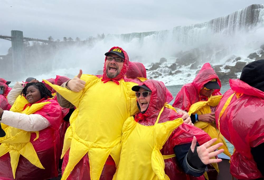 Some of the 309 people gathered to break the Guinness World Record for the largest group of people dressed as the sun pose on a sightseeing boat, before the total solar eclipse in Niagara Falls, Ontario, Canada, Monday. REUTERS